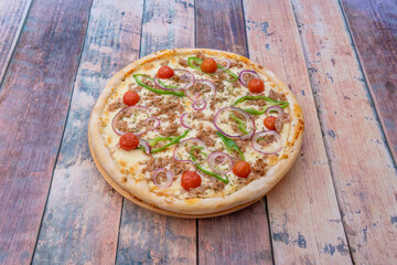 Tuna pizza with cherry tomatoes, red onion and green peppers with oregano and lots of melted mozzarella cheese