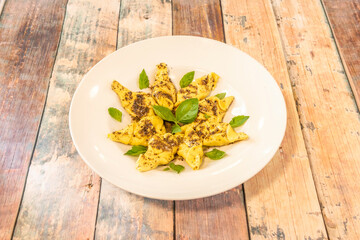 Italian recipe for ravioli with ricotta and truffle sauce with basil leaves with olive oil