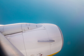 View from jet to ocean. Camera filming from aircraft porthole. Earth landscape and sea through window.
