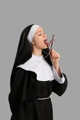 Sexy nun with cross on grey background
