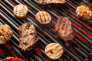 Tasty beef brisket with onion on barbecue grill