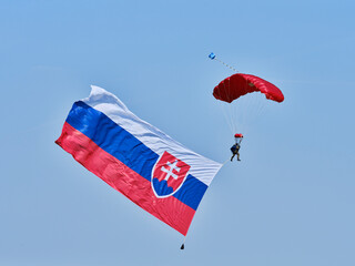 The parachutist flies with the Slovak flag behind him