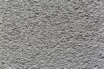 Sample of a texture of gray plaster. Wall finished with a decorative cement stucco. Example of exterior building decoration. Clean uniform grainy background. Banner. Wallpaper. Copy space. Pattern