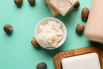 Bowl of shea butter and soap on color background, closeup