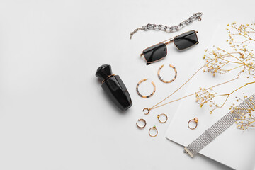 Composition with female accessories and bottle of perfume on white background, closeup