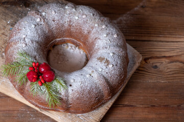 Christmas cake with a hole on a wooden board. Blur and selective focus.