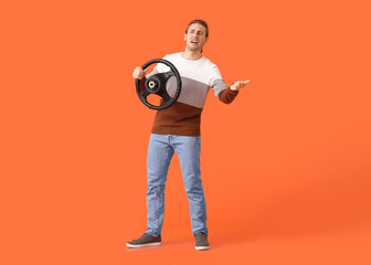 Angry young man with steering wheel on color background