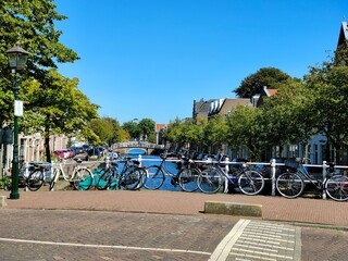 Haarlem, Amsterdam, Netherlands - September 2021 - Water channel in city center. Bridge with parked...