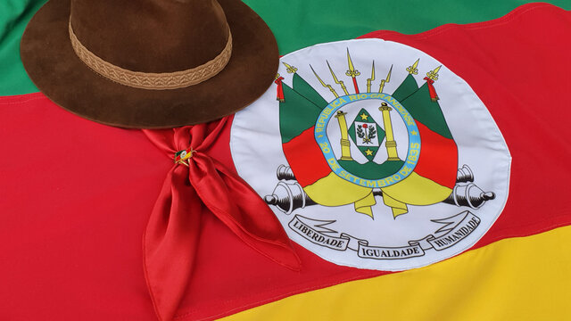 Hat, red gaucho scarf and State Flag of Rio Grande do Sul - Brazil, on the table. Decoration to commemorate the traditional Week in southern Brazil. Farroupilha from the Gauchos.