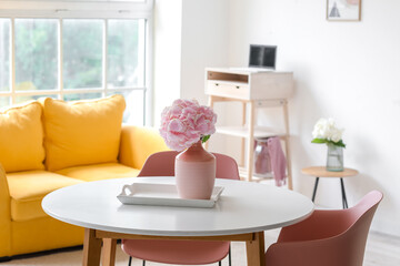 Vase with hydrangea flowers on table in living room
