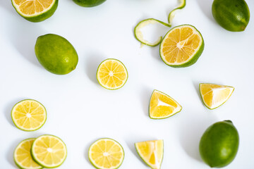 Flat lay view green lime lemons over isolated white backdrop.Includes copy space.