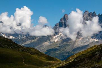 A hiking trail between Refuge de Bellachat and Aiguillette des Houches (near Chamonix and Les Houches), the view towards the Massif du Mont Blanc on a cloudy day in September.