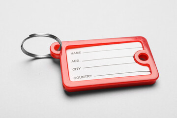 Plastic key tag on grey background, closeup