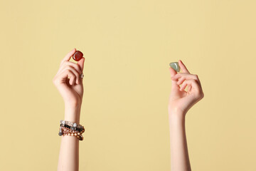 Female hands with beautiful gemstones on color background