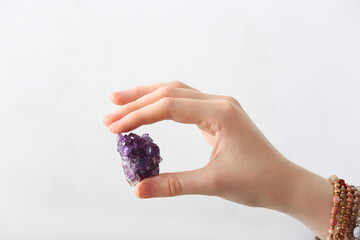 Female hand with beautiful amethyst on light background