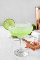 Glass with tasty daiquiri cocktail on light background