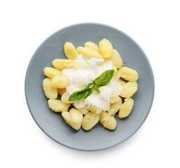 Plate of delicious gnocchi with creamy sauce on white background