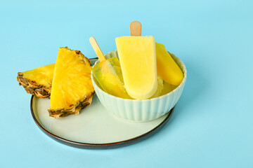 Bowl with tasty pineapple popsicles on color background