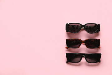 Stylish female sunglasses on color background