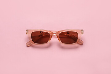 Naklejka premium Stylish female sunglasses on color background