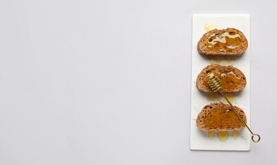 Delicious toasted bread with honey on light background