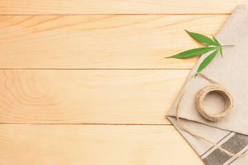 Hemp cloth with threads on wooden background