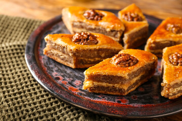 Plate with tasty baklava on table, closeup