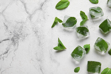 Ice cubes and fresh mint leaves on light background