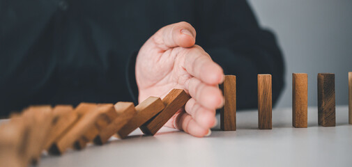 close-up hand The hand of a businessman who is stopping or preventing a falling block.Risk...