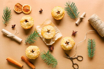 Fototapeta na wymiar Composition with tasty Christmas mince pies and fir branches on color background