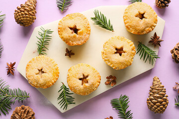Composition with Christmas mince pies, cones and fir branches on color background