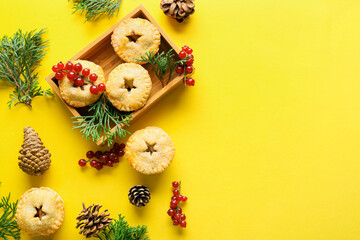 Composition with delicious Christmas mince pies, cranberry, cones and fir branches on color...