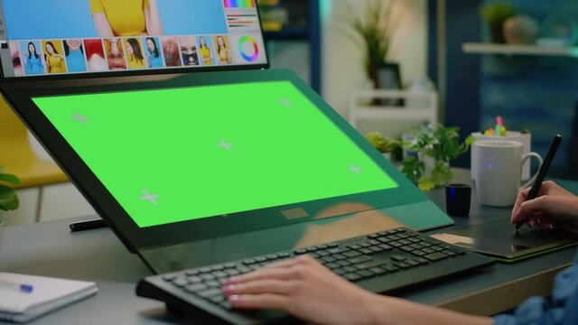 Close up of horizontal green screen on computer with retouching app. Photographer editing pictures with graphic tablet while having chroma key with mockup template and isolated background