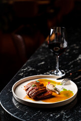Fine dining steak with meat juice and sprouts on a black marble table, texture visible