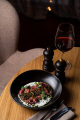 Elegant restaurant interior with a portion of an expensive meal on a table, empty armchair aside, no people