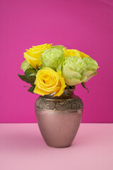 flower arrangement with roses inside a metal vase, decoration with beauty of colorful natural flowers in a studio, detail of nature and objects