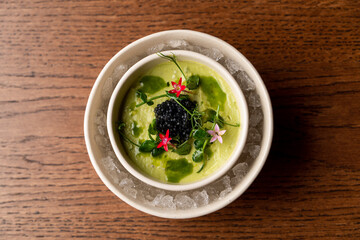 Top view of modern cuisine cold soup, beautiful summer cold soup with fresh flowers as a decoration