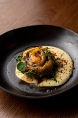 Close up of mega ravioli chicken filling, fine dining restaurant, black wide dish
