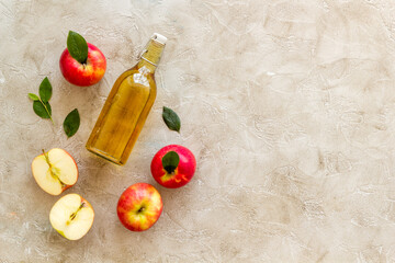 Homemade apple cider vinegar in glass bottle with red apples
