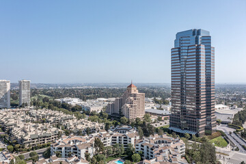 Aerial view of a tall skyscraper next to a residential neighborhood