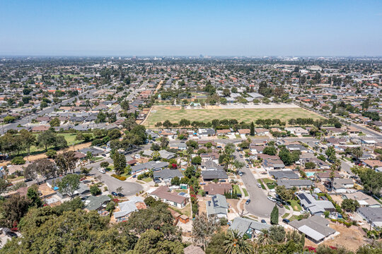 Aerial View Of A Los Angeles Suburban Neighborhood On A Hot Day, Large Sports Park, High School And Field
