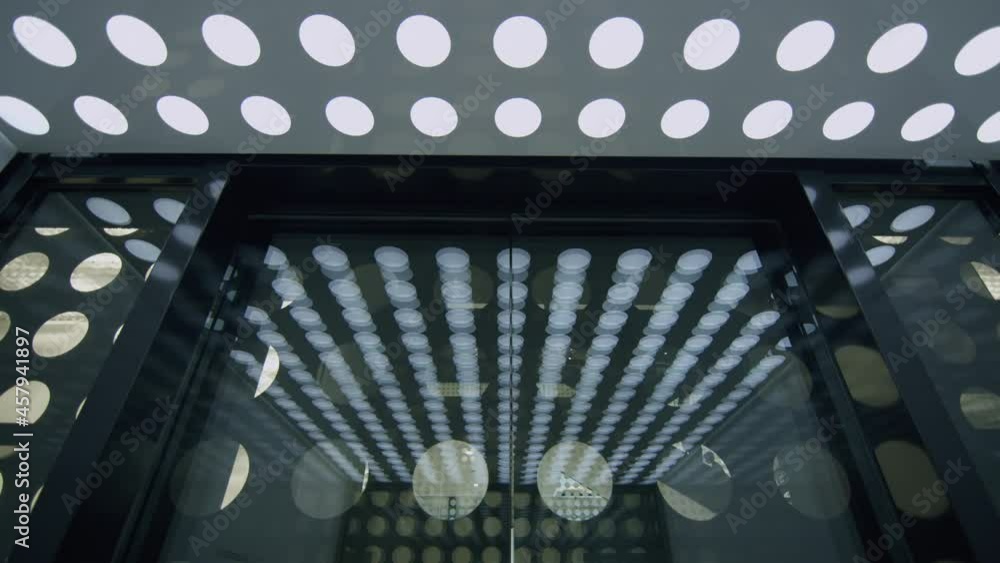 Poster slowmotion shot of inside elevator with circles pattern - doors closing and going up