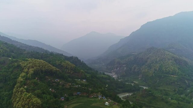 Aerial mysterious panorama above misty rural forest slopes over Marshyangdi river valley, Nepal 