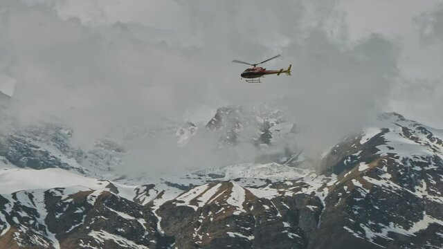 Helicopter fly above frozen snow mountains of Annapurna massif with huge clouds, Nepal 