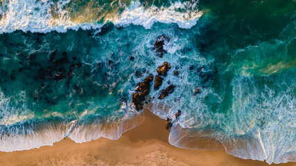 Türkisfarbenes Wasser mit Welle mit Sandstrand Hintergrundfelsen und Korallen aus der Luft von oben bei Sonnenuntergang. Konzept Sommer