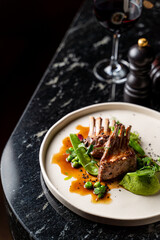 Side view of grilled ribs with red wine in a dark atmosphere of an empty restaurant