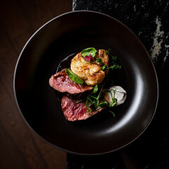 Gourmet steak with roasted cauliflower in a dark atmosphere of french restaurant