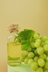 Grape seed oil.bottle and bunch of green grapes on green podium . Organic Natural Bio Grape Seed Oil. 