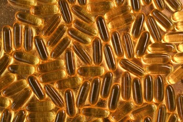 Fish oil gelatin capsules close-up on a gold background .omega fatty acids.Natural supplements.Healthy eating and food supplements.Natural supplements . High quality photo