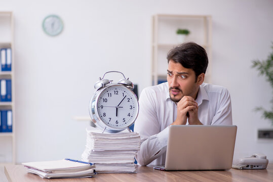 Young male employee in time management concept